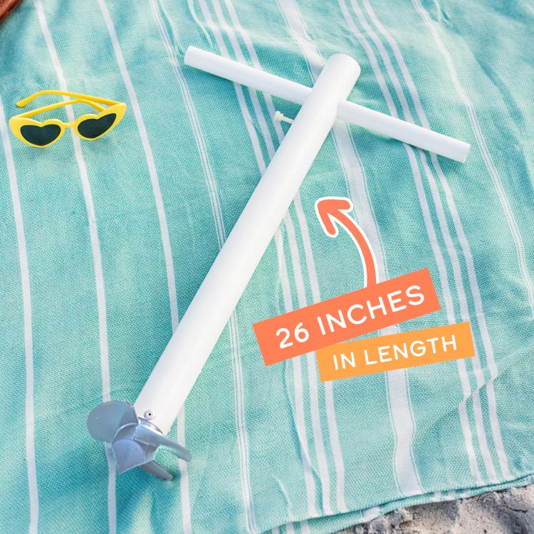 A product shot of the Suncoast Beach Shade umbrella anchor on top of a teal beach blanket with yellow heart sunglasses off to the side with the words "26 Inches in Length" on top of the image